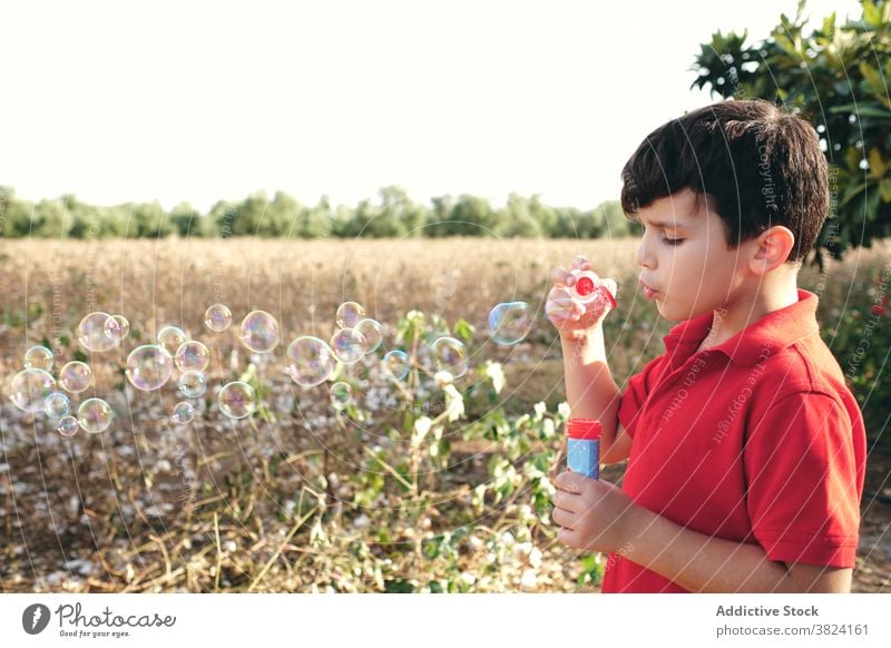 Boy blowing soap bubbles in summer child boy entertain having fun park outfit relax casual adorable holiday rest enjoy nature cute weekend kid carefree pleasure