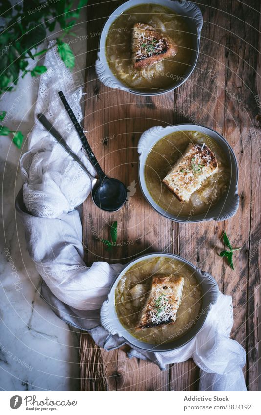 Bowl of french onion soup on wooden surface cream soup vegetable bowl bread cuisine food foodcollection herbage veggies cooked lunch cheese crouton dinner