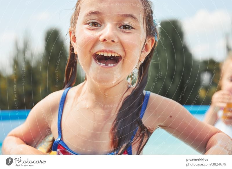 Portrait of happy smiling girl standing in a pool having fun on a summer sunny day authentic backyard childhood children family garden happiness joy kid