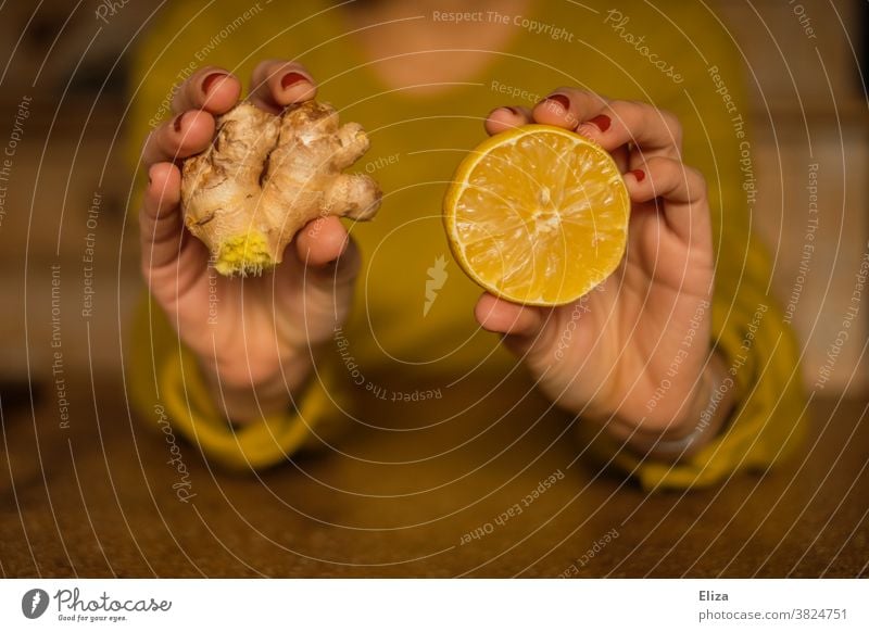 Strengthen the immune system during the cold season: Woman holds half a lemon and a piece of ginger. Ginger Lemon salubriously Common cold cold spell