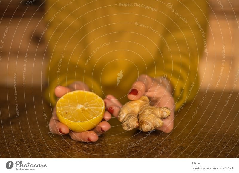 Strengthen the immune system during the cold season: Woman holds half a lemon and a piece of ginger. Ginger Lemon salubriously Common cold cold spell