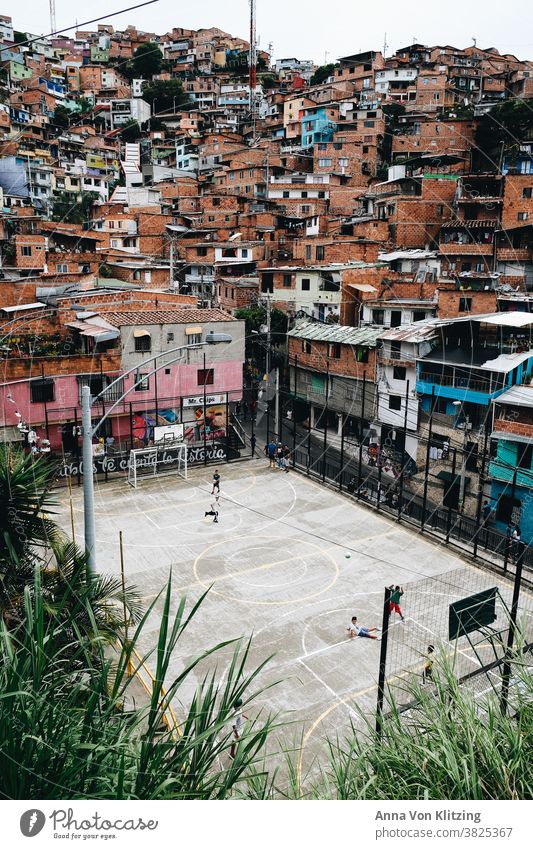 Football pitch in Medellin Foot ball medelline colorful houses Playing children variegated Colombia Town urban densely populated colourful playing children