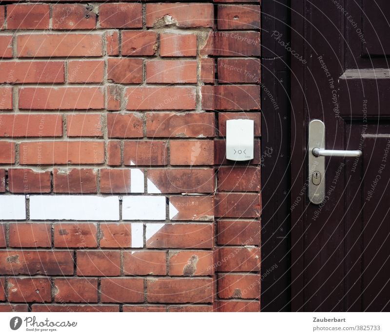 brick wall, white arrow, bell and wooden door Arrow Indicate Wall (building) clinker Brick red door handle Entrance Clue Wooden door Brown locked Road marking