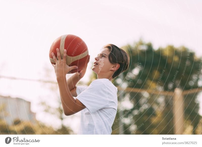 Close-up of a young athlete's hands holding a basketball. The athlete is preparing to throw. Sport, athlete throwing player boy healthy exercise athletic field
