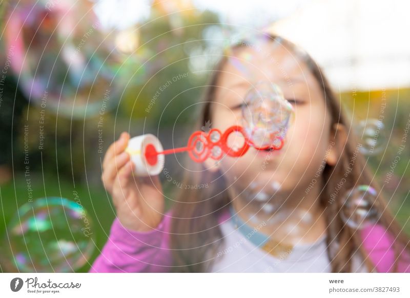 A little girl makes soap bubbles in the garden caucasian child childhood floating flying. burst fragile fun human playing shimmering tender toddler toddlerhood