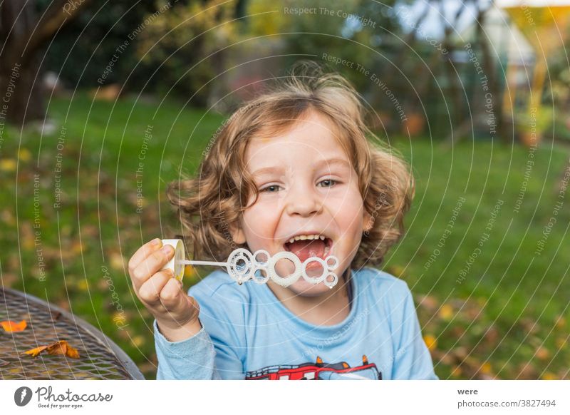 A little boy makes soap bubbles in the garden caucasian child childhood floating flying. burst fragile fun human playing shimmering tender toddler toddlerhood