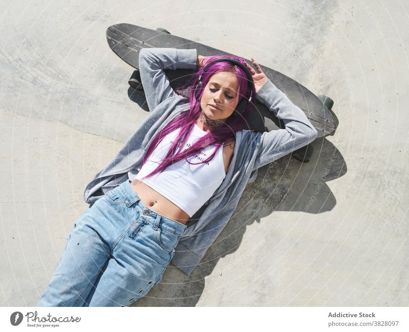 Determined woman with longboard in city millennial independent informal young pink hair fancy skater confident female modern hipster fashion trendy style