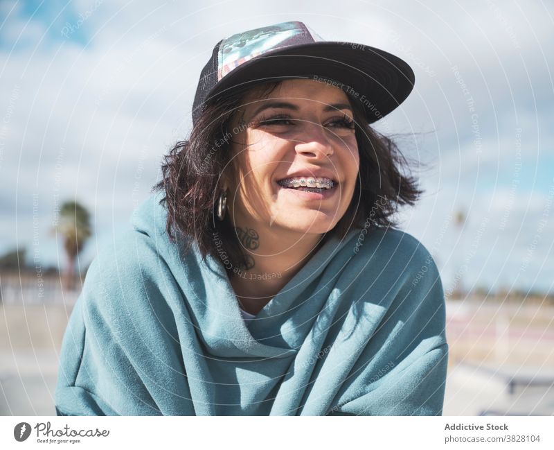 Positive informal woman having fun in city hipster young rebel tattoo skate park subculture weekend female outfit street cheerful joke laugh trendy style urban