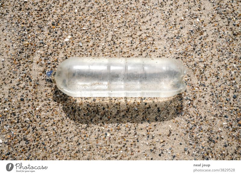 Empty plastic bottle on the beach - transparent Trash plastic waste Environmental pollution Recycling Plastic Water Bottle of water Bright Sand Beach top view