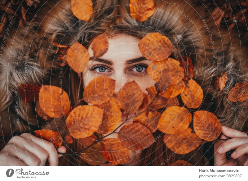 woman holding autumn leaves as natural face mask autumn colors autumn vibes background beautiful beautiful woman caucasian celebration clean close up clothes