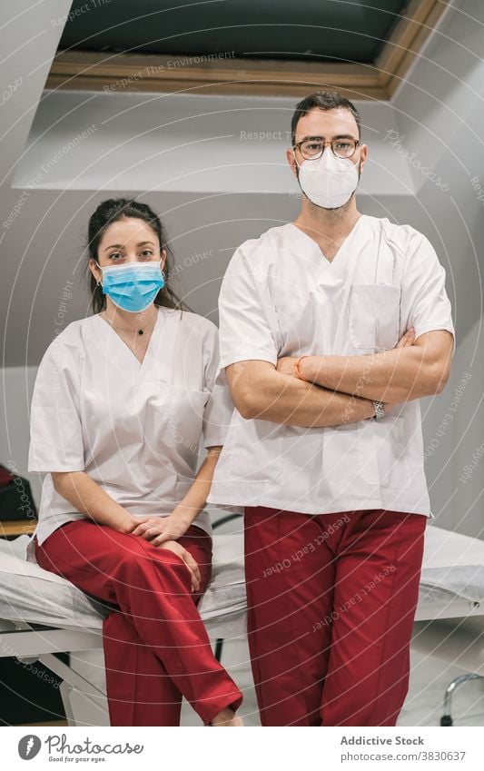 Smiling doctors in uniform and mask looking at camera medic hospital staff cheerful smile occupation specialist professional medical stand service medicine