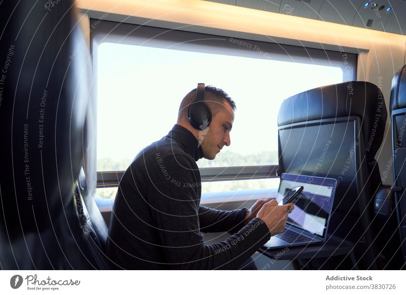 Busy man working in train during business trip entrepreneur businessman freelance smart laptop male passenger browsing seat smartphone project internet online