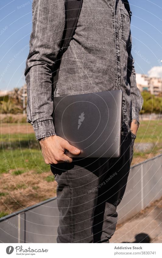 Man in casual outfit carrying laptop man employee equipment gadget work freelance modern occupation job male street digital young netbook business internet