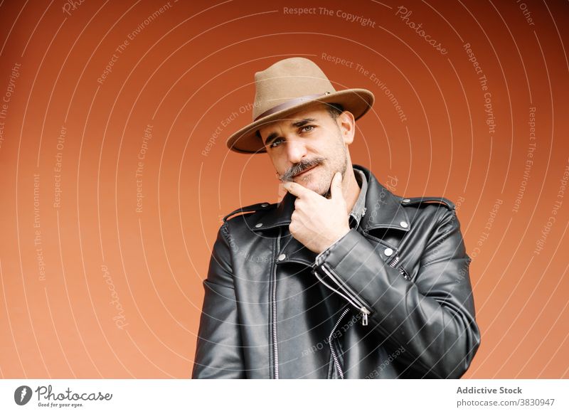 Serious man with mustache in hat curl leather jacket male pretend metrosexual optimist confident friendly trendy guy contemporary mature handsome charismatic