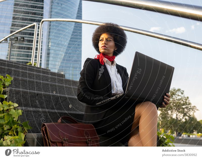 Black businesswoman working on laptop on steps using entrepreneur serious communicate remote female executive connection device concentrate gadget online