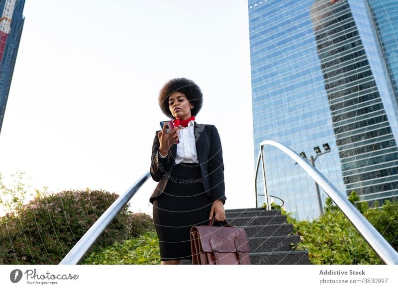 Black businesswoman on smartphone confident call using entrepreneur listen formal conversation executive female briefcase serious mobile device professional
