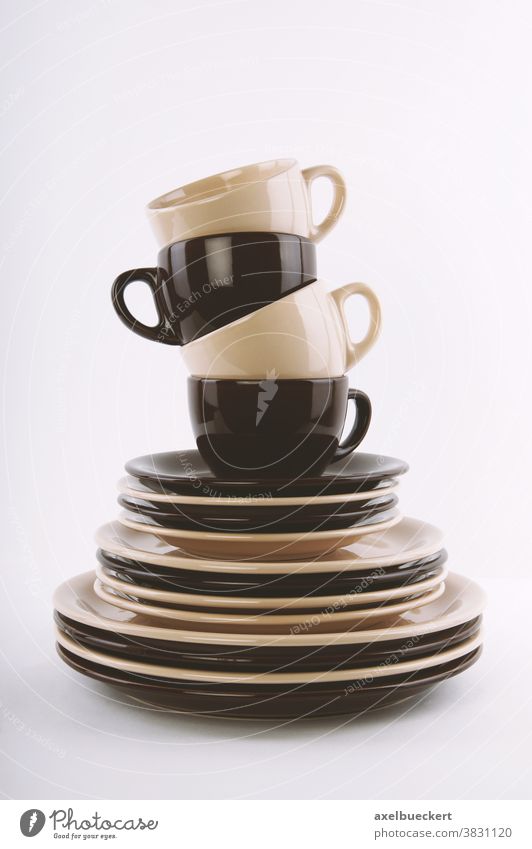 stack of clean dishes in brown and beige dishware crockery tableware pile stacked piled plate plates cup cups saucer saucers side plate dinner plate dinnerware