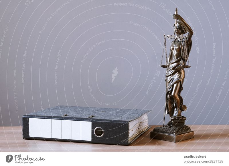 lady justice or justitia statue and file folder on desk law legal right table jurisprudence jurisdiction paperwork document office sculpture profession