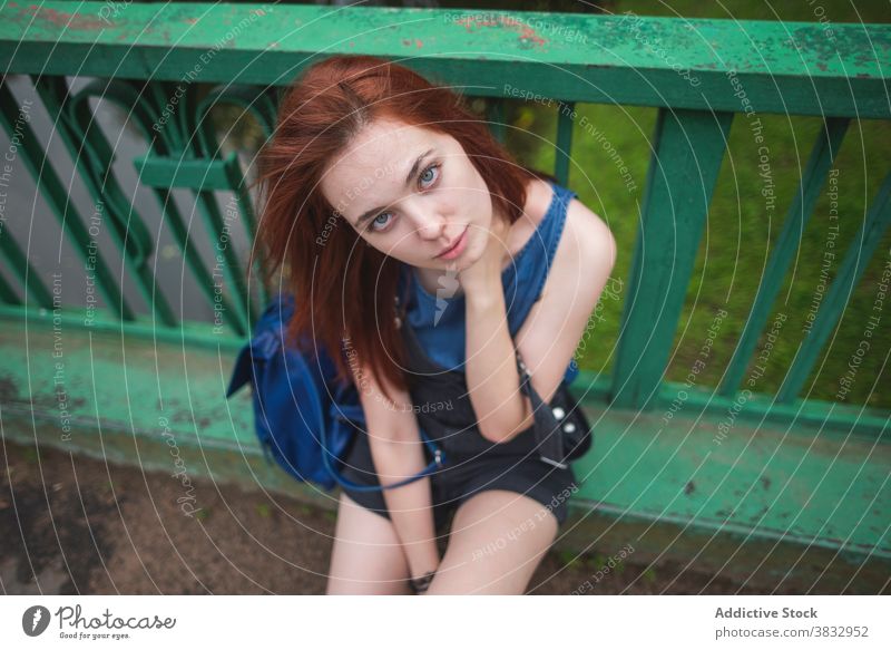 Millennial woman resting on bridge fence millennial hipster adolescent red hair alone style urban female teenage student traveler railing shabby lifestyle young