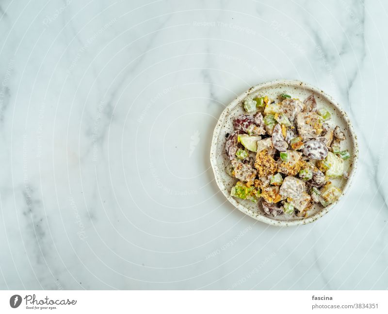 Waldorf salad on white marble,copy space,top view waldorf salad flat lay delicious tasty american fruit nut apples celery grapes chicken meat dressed vegetable