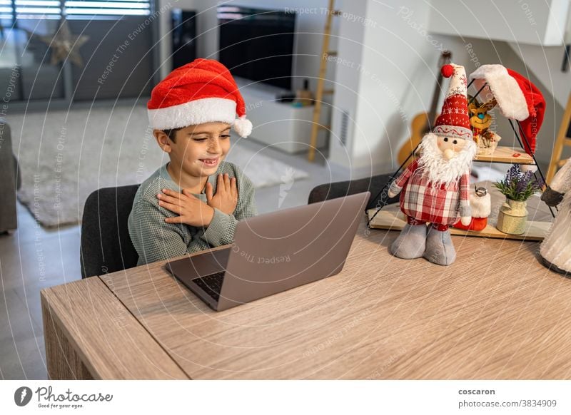 Little kid making a video call with the family on Christmas alone boy camera celebration chat child childhood children christmas claus communication computer