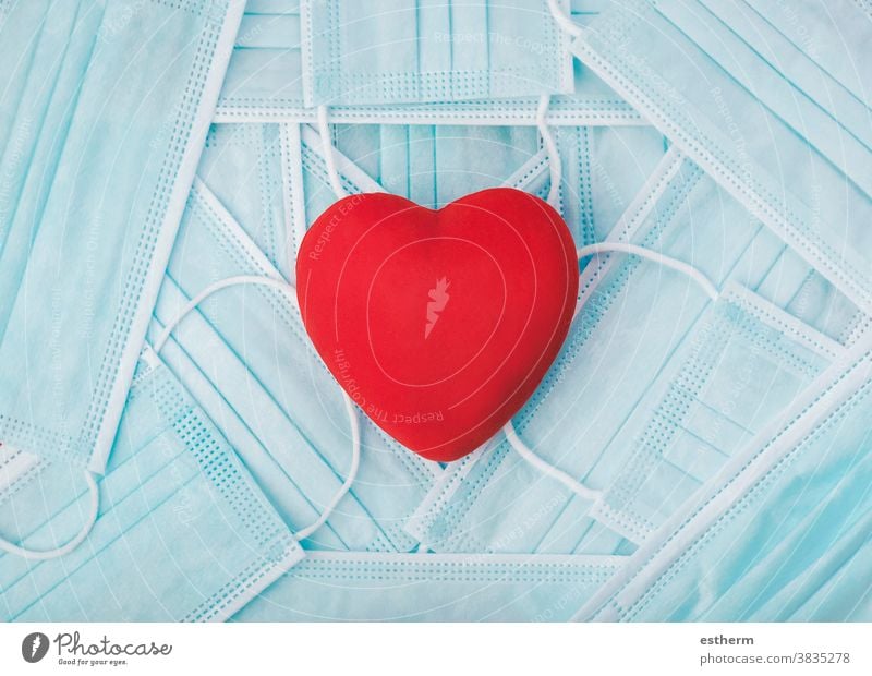 Red heart on a pile of medical face masks. Covid 19 concept coronavirus protective surgical mask medical mask 2019-ncov covid 19 epidemic pandemic quarantine