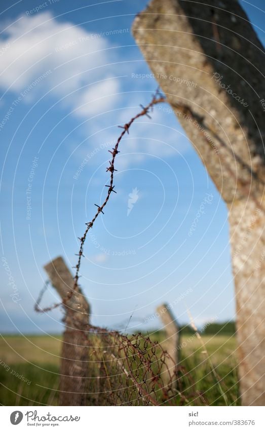 barbed wire Landscape Sky Clouds Summer Concrete Metal Rust Aggression Threat Historic Broken Point Thorny Blue Brown Gray Green Might Sadness Death Fear