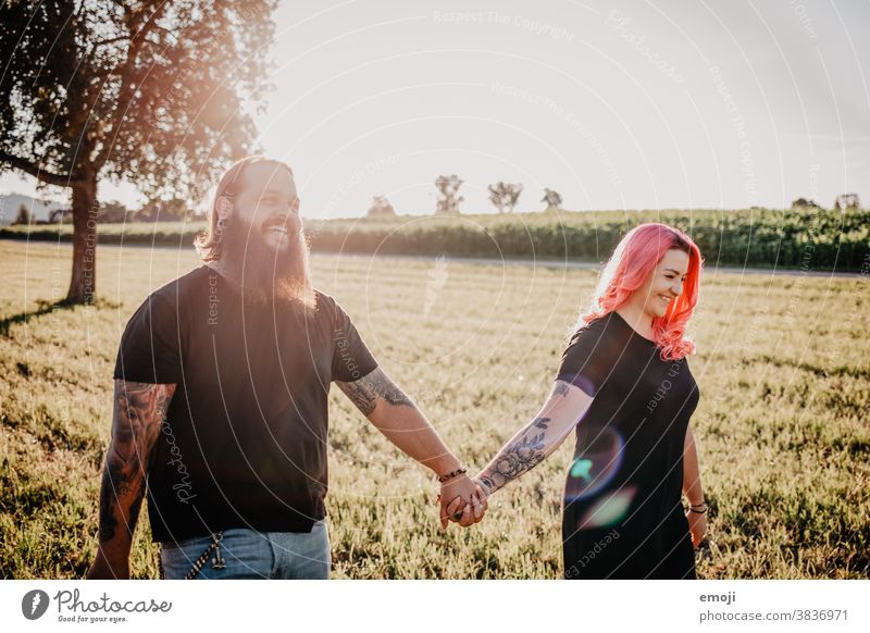 young couple with tattoos and pink hair hand in hand teen Couple Love In love out Field Tattoo Hip & trendy Hipster Man Woman Going Sunlight fortunate