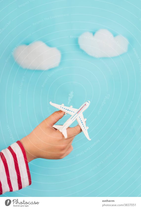 child hands holding a toy airplane over clouds. Travel concept travelling voyage explore aviator travel agency travel concept kid blue destination traveler