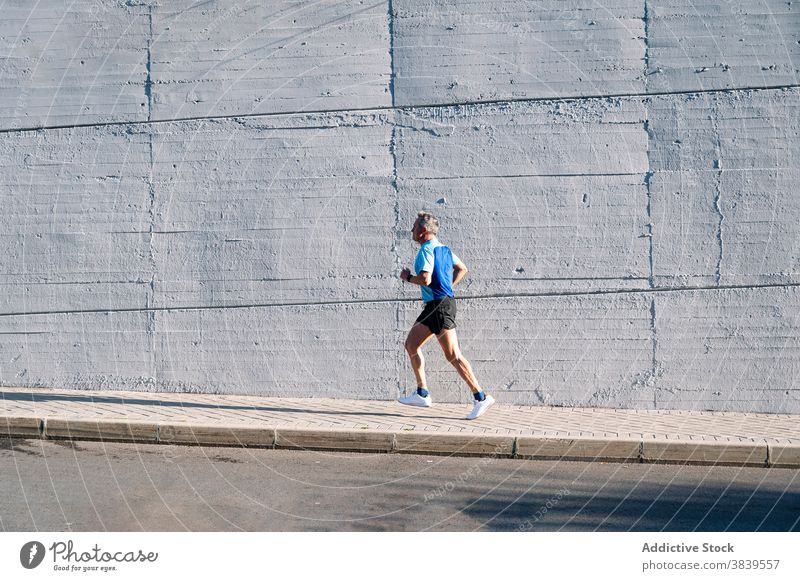 Senior retired man runs down the street 58 rest rythm health care fitness high-blood-pressure training cardiac old neck rate caucasian check sport old man time