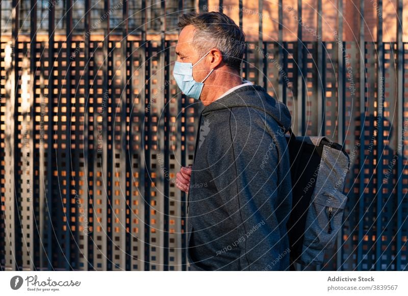 Senior retired man with face mask and sportswear walking down the street 58 rest rythm health care fitness high-blood-pressure training cardiac old neck rate