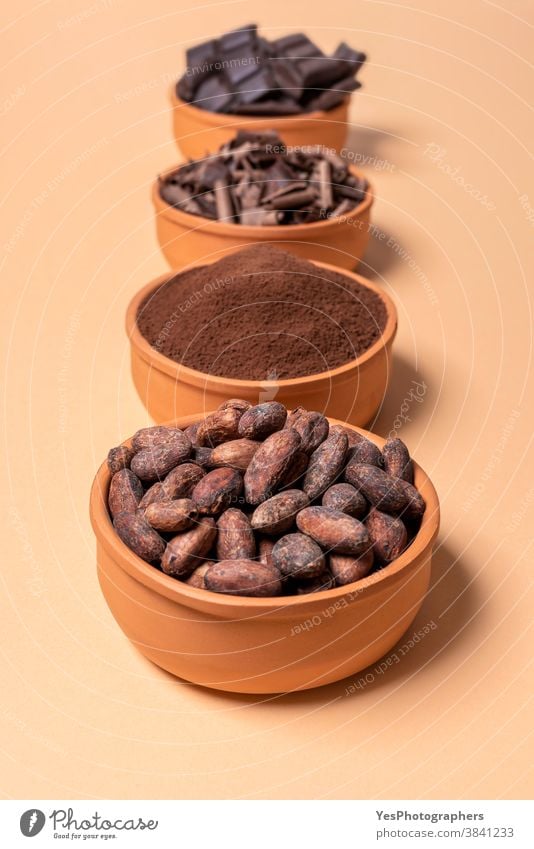 Cacao beans in a bowl and chocolate isolated on beige background assortment baking bitter bowls cacao cacao beans chocolate chips chocolate chunks