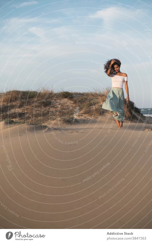 Serene woman walking on sandy beach at sunset carefree summer barefoot grace tranquil female outfit hill nature charming enjoy sundown freedom young smile