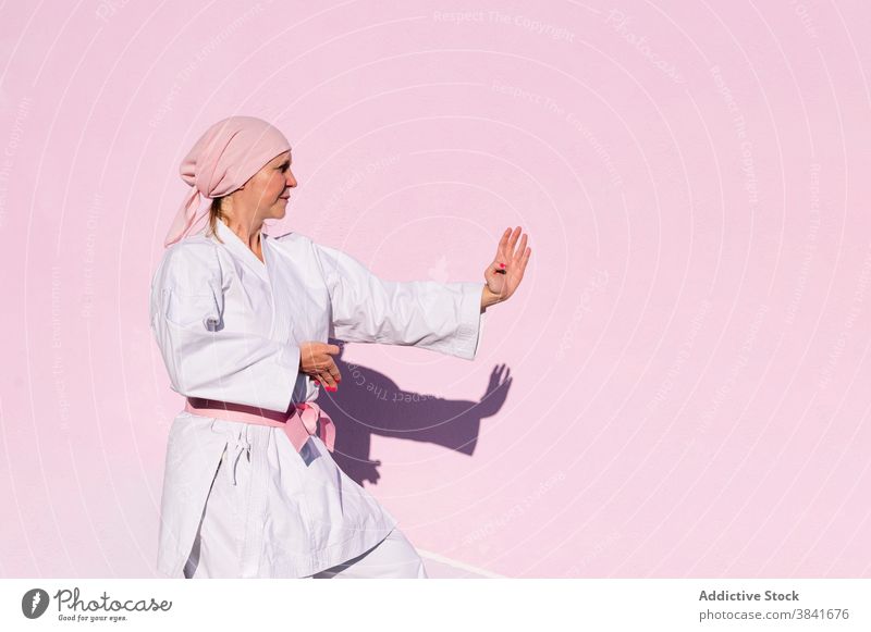 Karate woman who has defeated cancer karate martial sport campaign awareness health female fighter pink foulard confident disease remission strong oncology