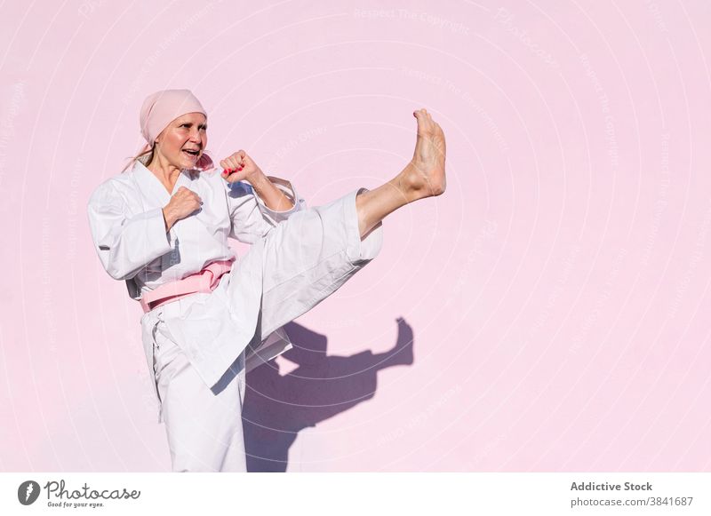 Karate woman who has defeated cancer karate martial sport campaign awareness health female fighter pink foulard confident disease remission strong oncology