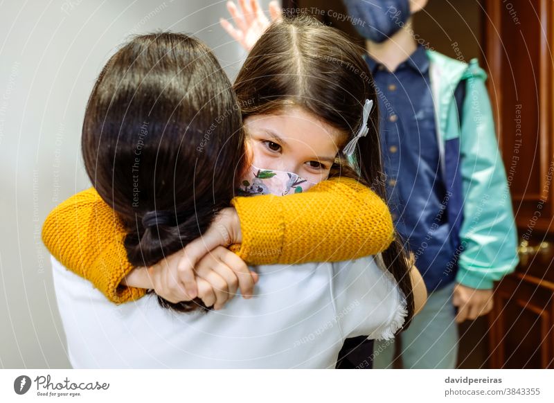 Mother hugging daughter with mask coming back from school mother after protective mask covid-19 before coronavirus son girl safety young kid child say goodbye