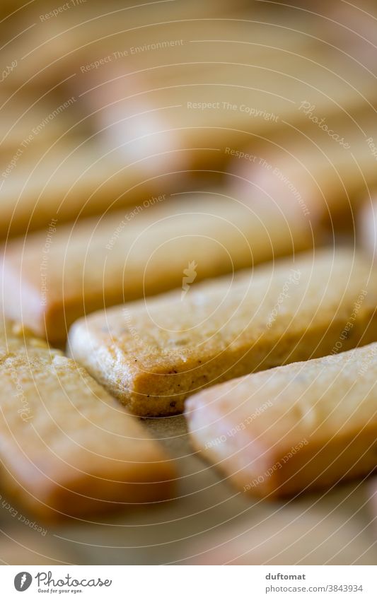 Baked goods lying orderly on baking paper Cookie dough Rolling pin Food Nutrition Baking Close-up cute Delicious Christmas biscuit Shallow depth of field