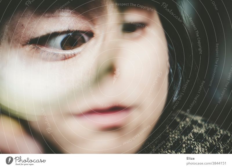 Distorted face of a woman looking through a magnifying glass Magnifying glass Eyes warped Funny Squint obliquely Face Grimace Looking inquisitorial Enlarged