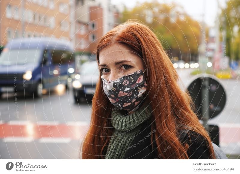 young woman wearing everyday cloth face mask outdoors in city raffic street traffic corona winter air pollution real people everyday mask community mask