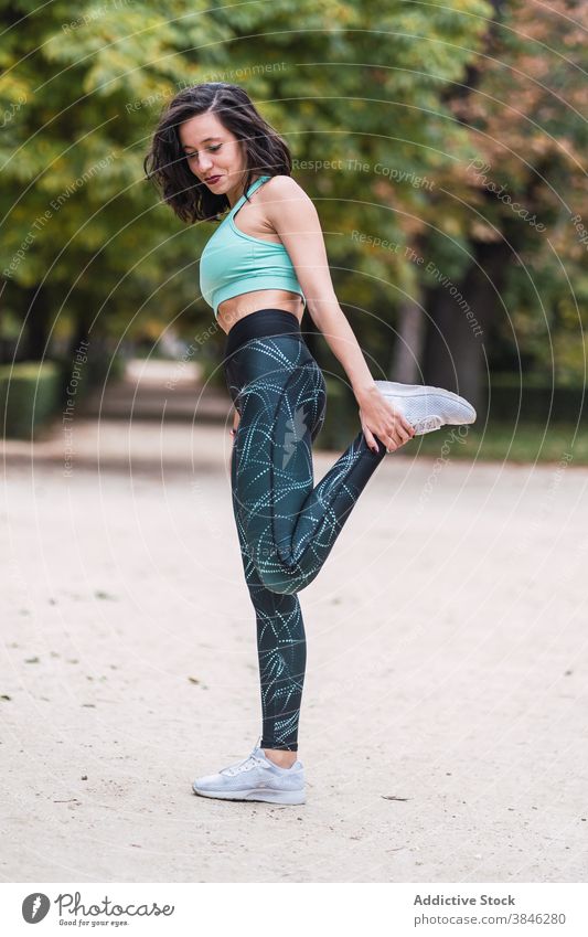 Slim woman stretching arms during workout - a Royalty Free Stock