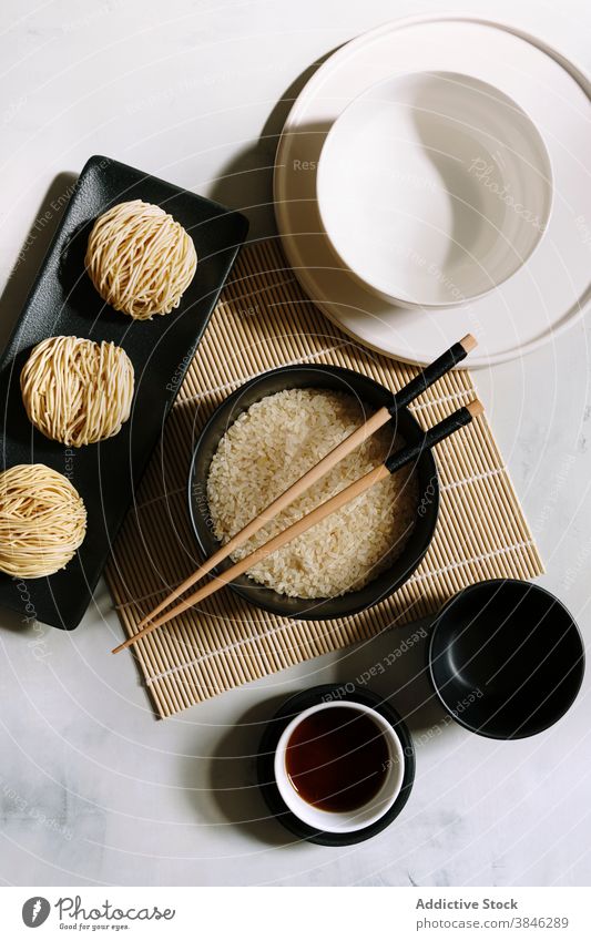 Asian dishes arranged on table asian food noodle oriental chopstick soy sauce bamboo mat dry rice tradition bowl wooden cafe serve cuisine healthy meal tasty