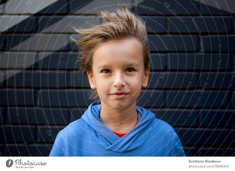 Funny portrait of a blonde Caucasian boy whose hair rises and flies in the wind. Looks into the camera Boy (child) Child Infancy background Happy Cute fun