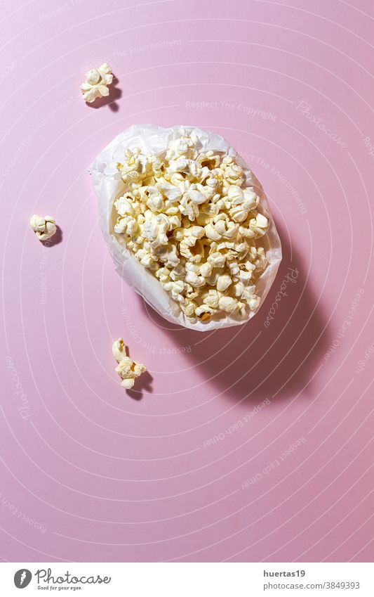 Homemade popcorn on on colorful backgrounds snack entertainment food delicious tasty salty salted fresh fluffy classic sweet paper modern takeaway design
