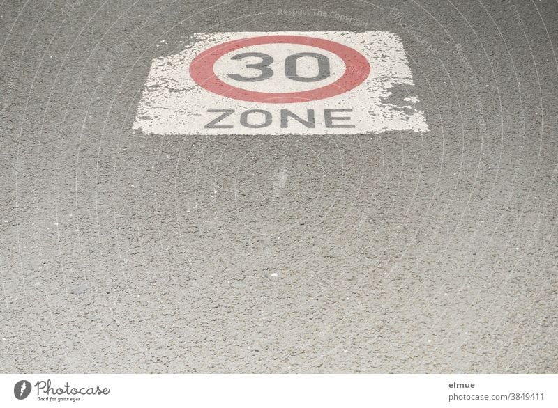 A speed limit sign "Zone 30" is painted on the asphalt road / traffic-calmed zone / drive slowly / speed limit 30 Road sign Speed limit 30 mph zone at 30 kph