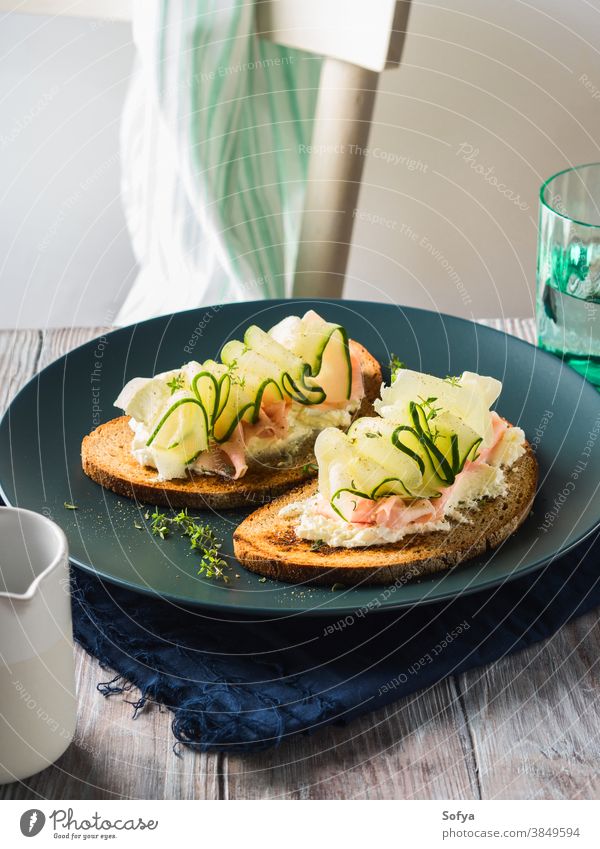 Rye bread toasts with cheese, ham, cucumber sandwich food vegetable fresh slice rye breakfast set wooden black dish delicious lunch brunch meal trendy styling