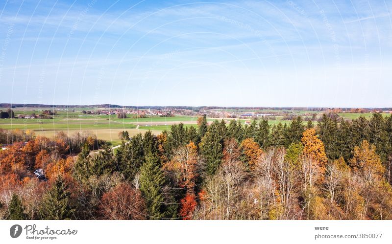 View from above over autumnally colored trees and the foothills of the Alps Area flight Autumn Windach Wooden park bench aerial view autumn color autumn forest