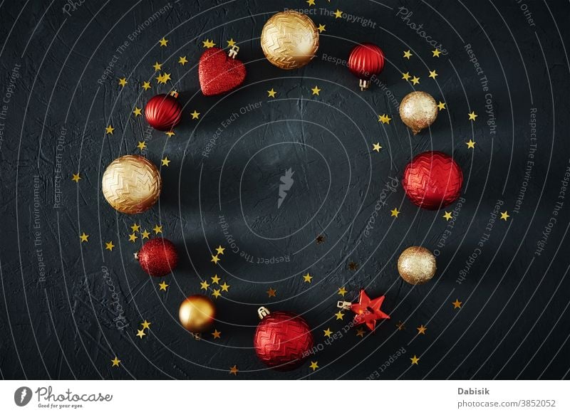 Christmas composition. Round frame of red and golden Christmas baubles and festive ribbons on dark background, top view Decoration Composition of the creatively