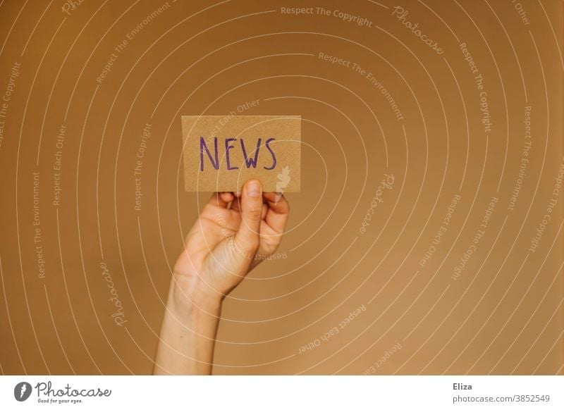 Hand holds up a sign saying News. Concept News, Newsletter, News. news English News & Events Information Journalism Print media Media Press message transmission