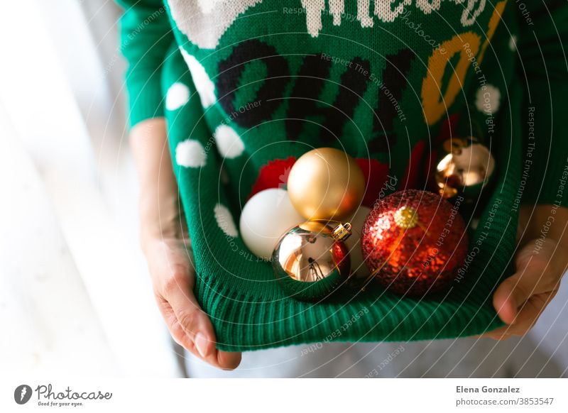 Unrecognizable woman holding Christmas tree balls in a Christmas jumper with lights christmas merry christmas new year december christmas balls women baubles