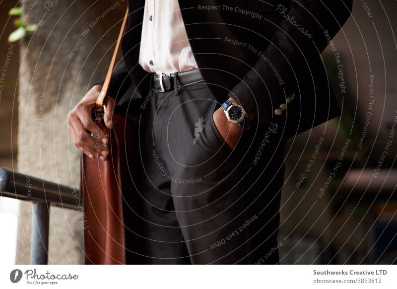 Close Up Of Businessman With Leather Bag Standing With Hand In Pocket business businessman office worker close up standing outdoors hand in pocket suit watch